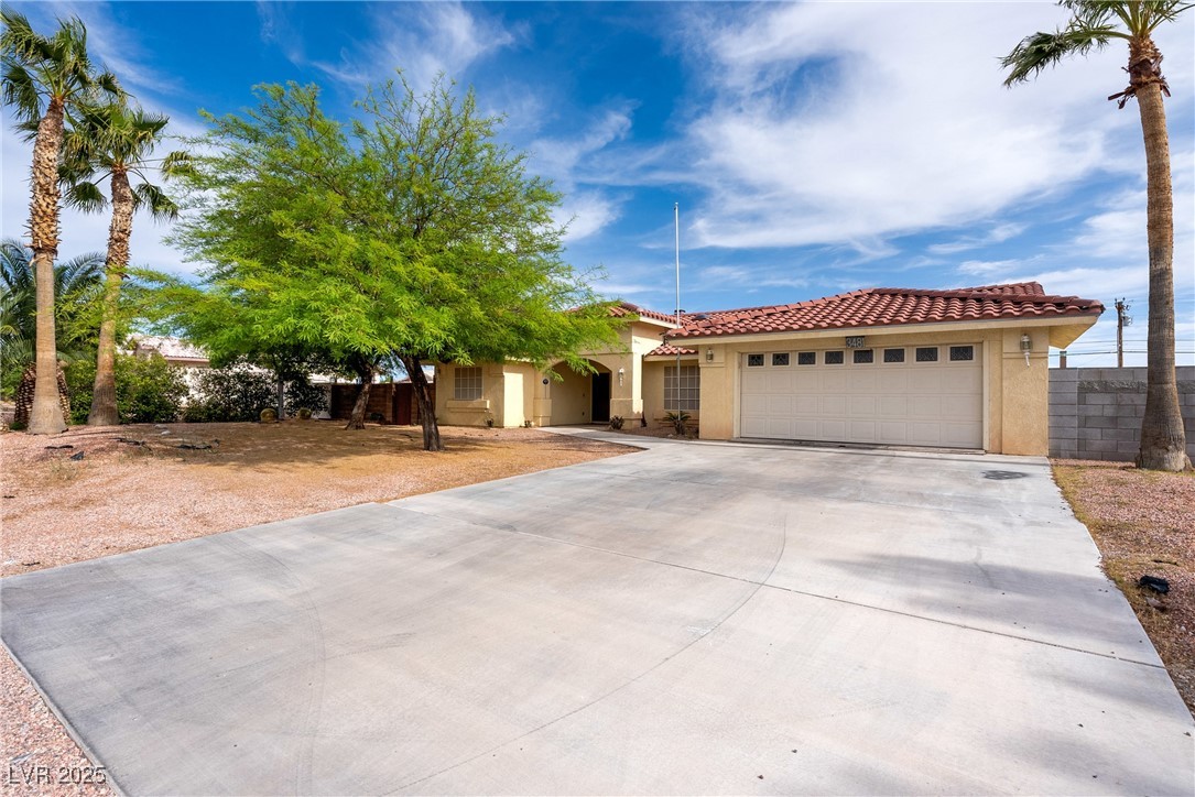 3481 Winery Road Pahrump, NV 89048 - Photo 31 of 34 View of front of home featuring stucco siding, concrete driveway, an attached garage, and a tiled roof