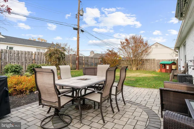 a view of a backyard with table and chairs potted plants and a big yard