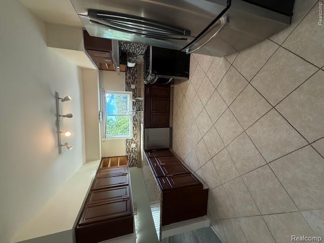 43038 Hanford Road Canton, MI 48187 - Photo 14 of 36 Spacious kitchen featuring extensive dark wood cabinetry, granite countertops, stainless steel appliances, a patterned tile backsplash, and light-toned tile flooring