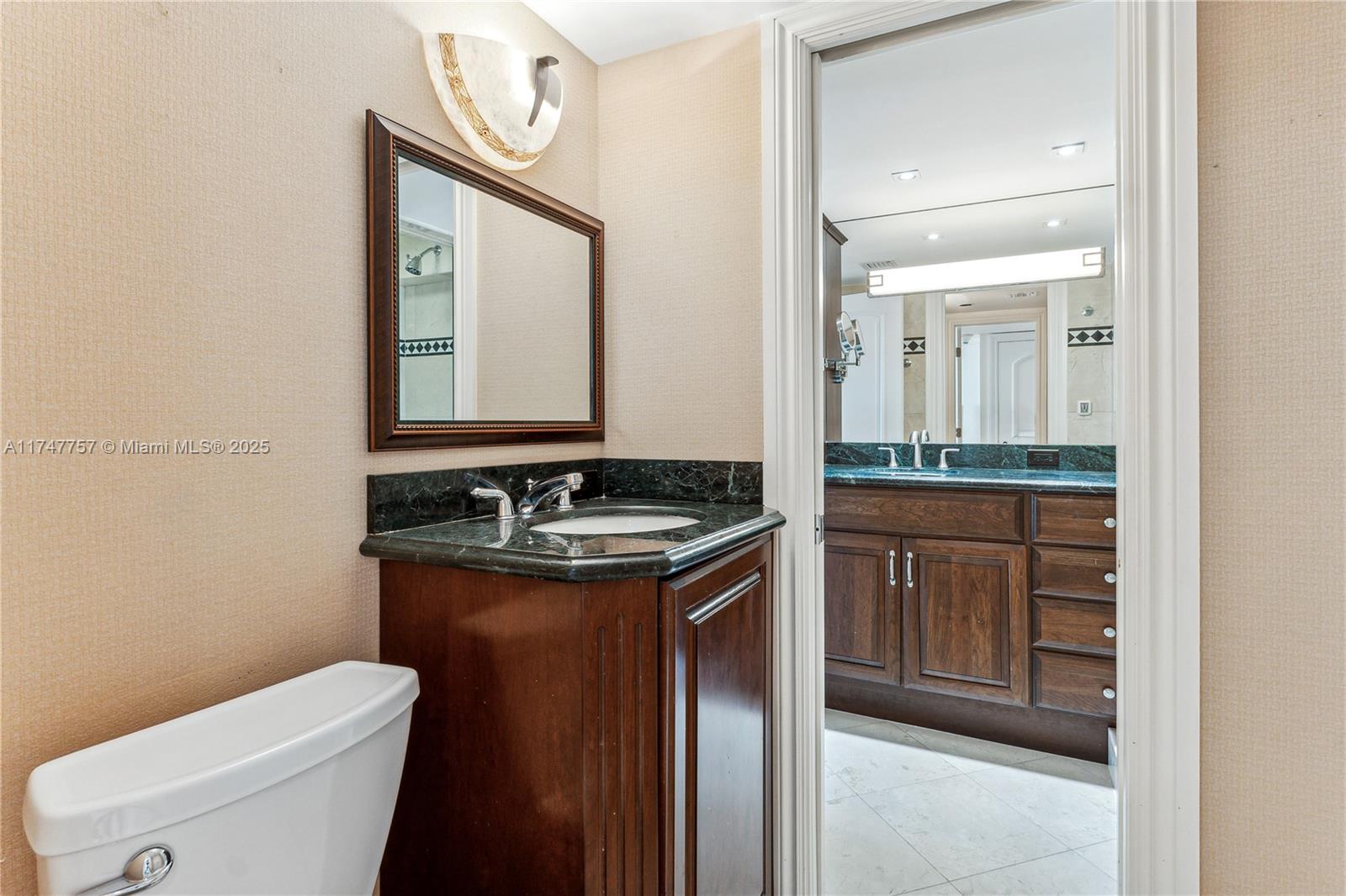 4000 Towerside Terrace, Unit TS3 Miami, FL 33138 - Photo 31 of 49 a bathroom with a granite countertop sink a toilet mirror and vanity