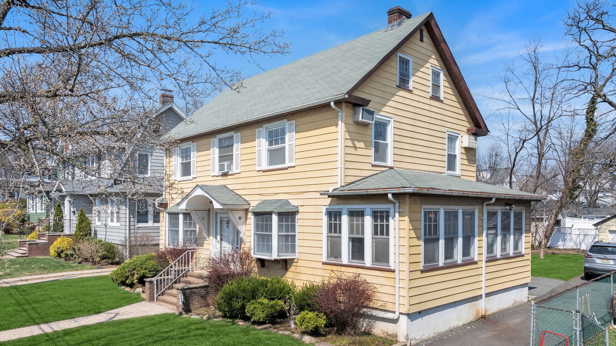 a view of a white house with a yard and plants