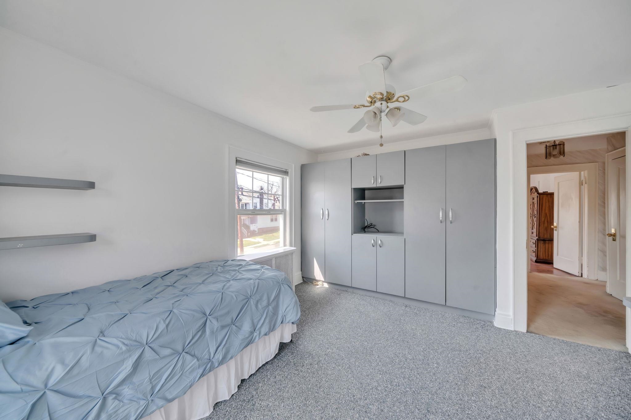 865 Livingston Road Elizabeth, NJ 07208 - Photo 29 of 39 a spacious bedroom with a bed and a chandelier
