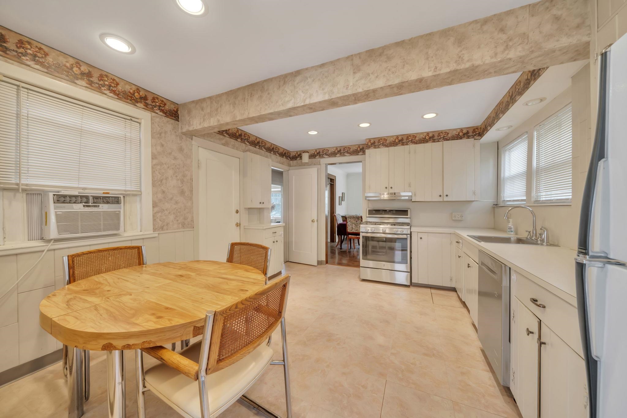 865 Livingston Road Elizabeth, NJ 07208 - Photo 6 of 39 a kitchen with stainless steel appliances kitchen island granite countertop a table chairs sink and cabinets