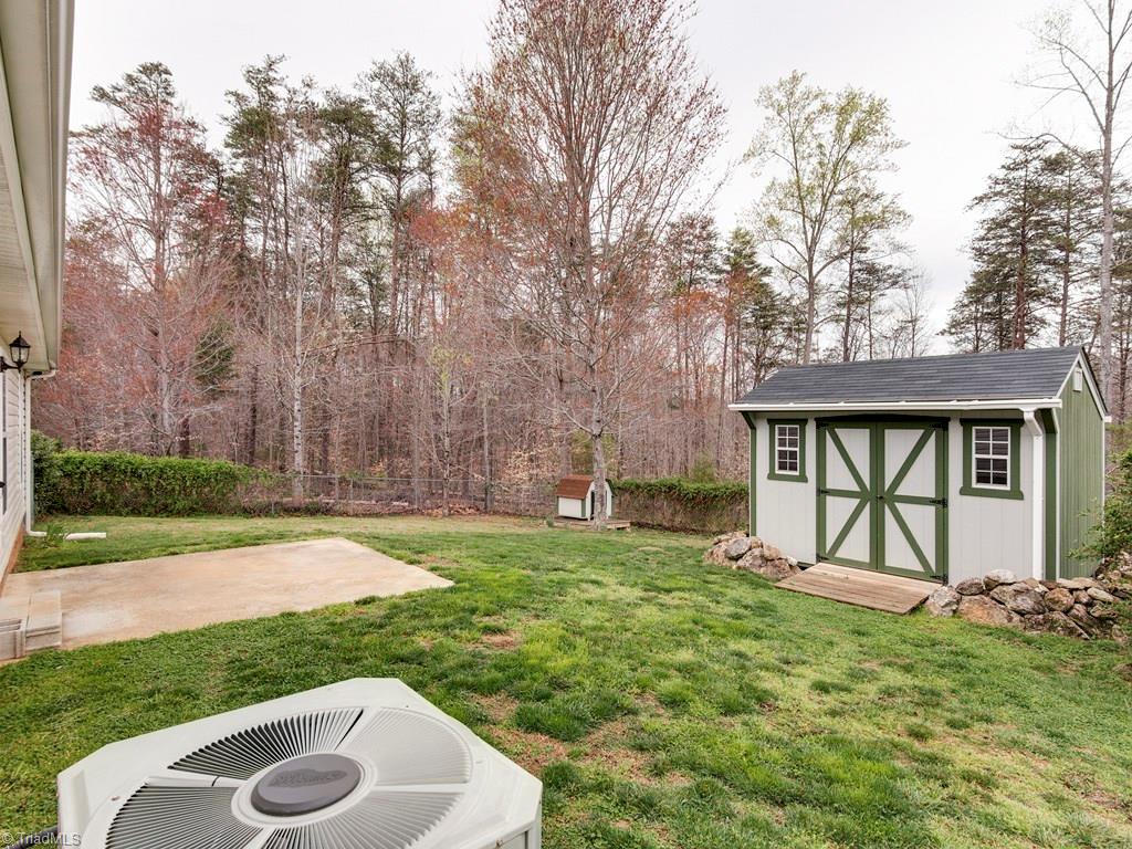 8124 Shoeline Road Stokesdale, NC 27357 - Photo 22 of 29 The home has a large patio and storage shed.