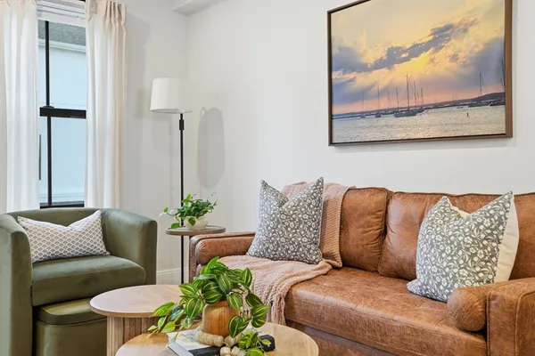 a living room with furniture and a painting on the wall