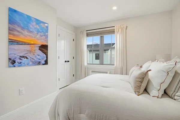 a bedroom with a bed and a painting on the wall