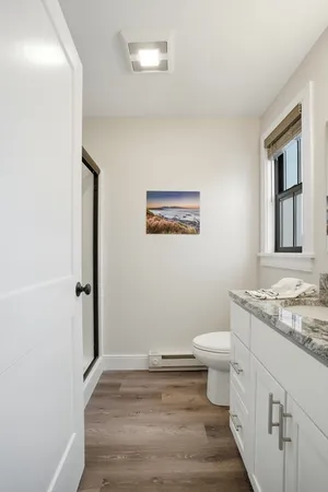 a bathroom with a granite countertop toilet and a sink