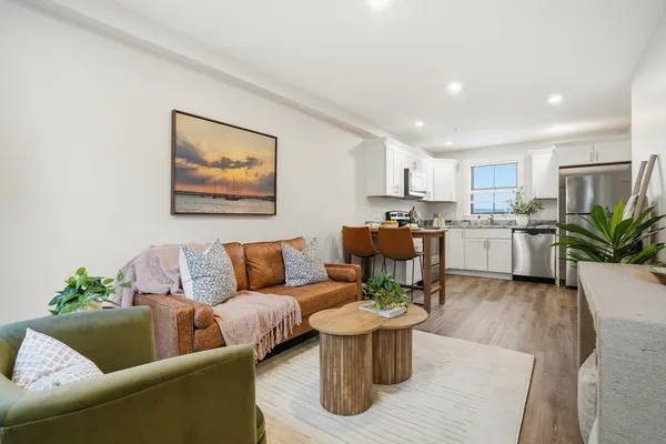 a living room with furniture and a dining table with potted plant