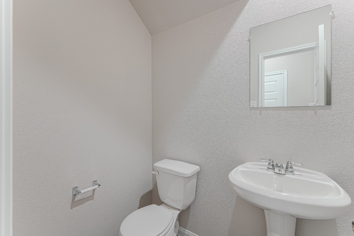 9219 Grace Rdg Drive Willis, TX 77318 - Photo 33 of 36 a bathroom with a toilet sink and mirror