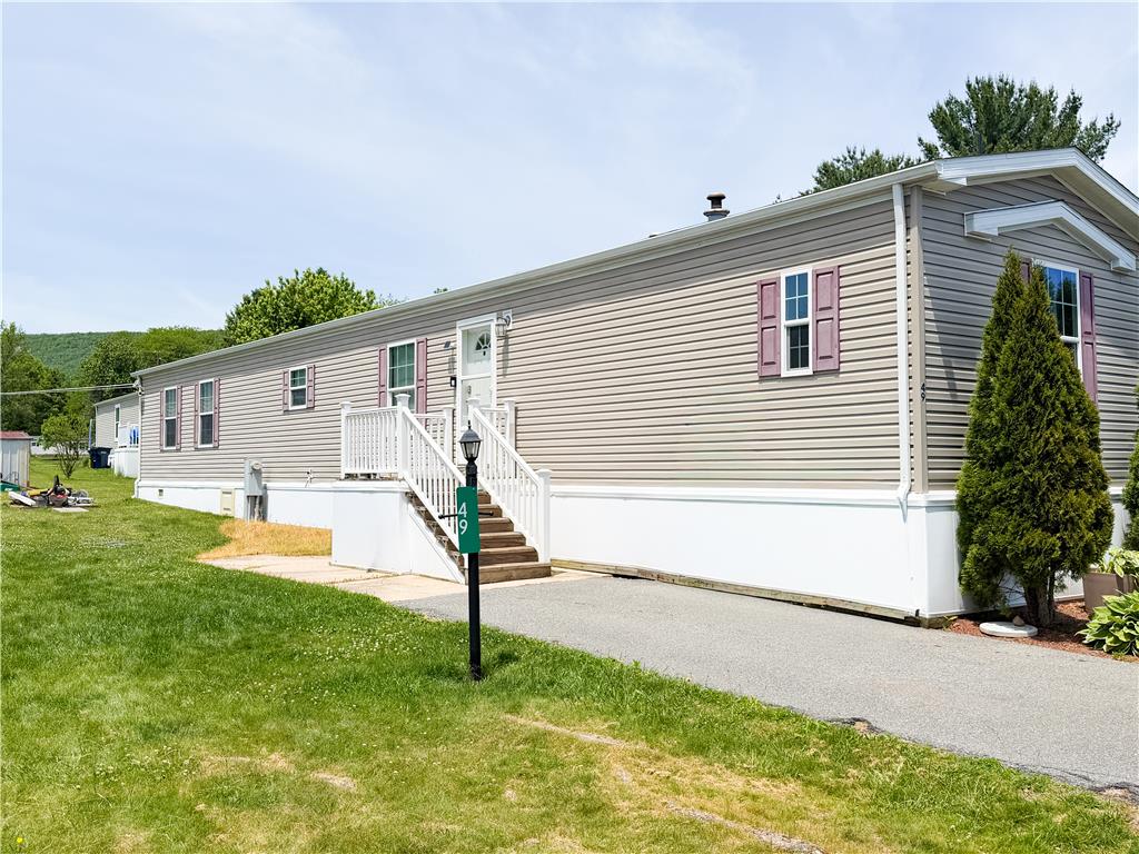 49 Ritz Craft Street Walnutport, PA 18088 - Photo 4 of 17 A well-maintained manufactured home with inviting front steps and a verdant yard awaits.