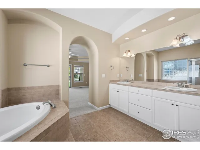 a spacious bathroom with a granite countertop sink mirror and bathtub