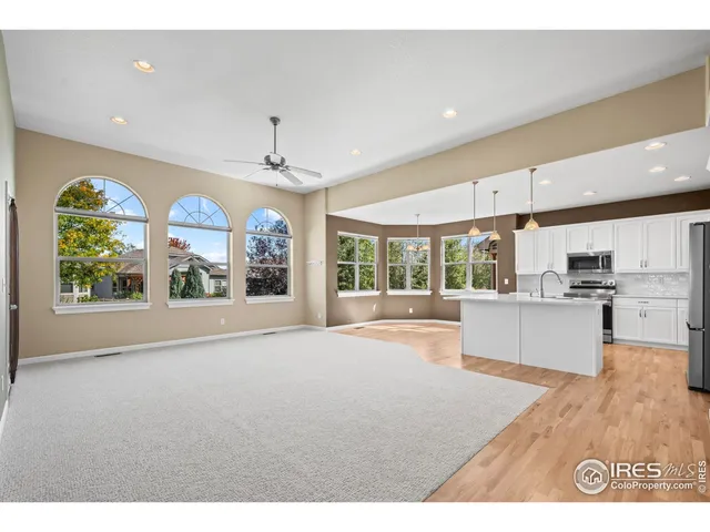 a large kitchen with stainless steel appliances granite countertop a large window