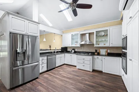 a kitchen with granite countertop a stove a sink and a refrigerator