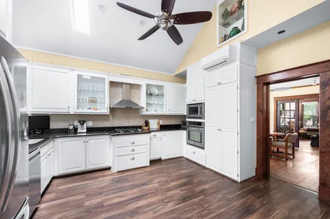 a kitchen with granite countertop a refrigerator and wooden floor