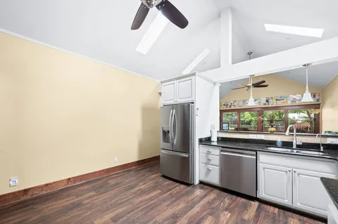 a view of a kitchen with wooden floor and electronic appliances