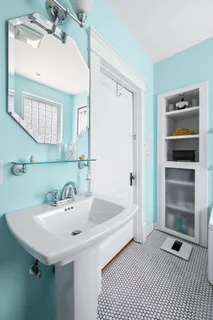 a spacious bedroom with a bed a couch and large window