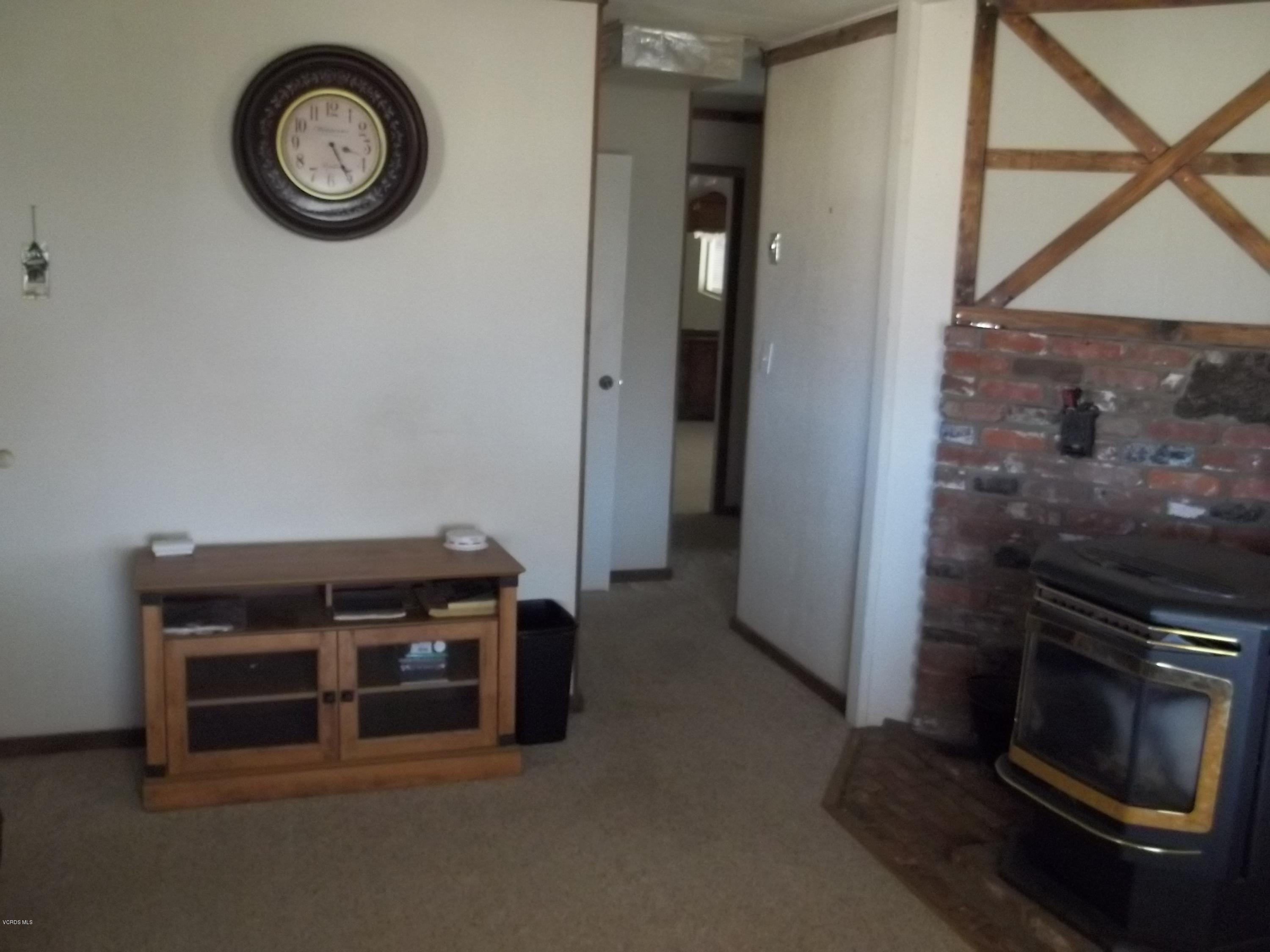 19370 Water Canyon Road Tehachapi, CA 93561 - Photo 17 of 38 a view of an empty room with wooden floor and a clock