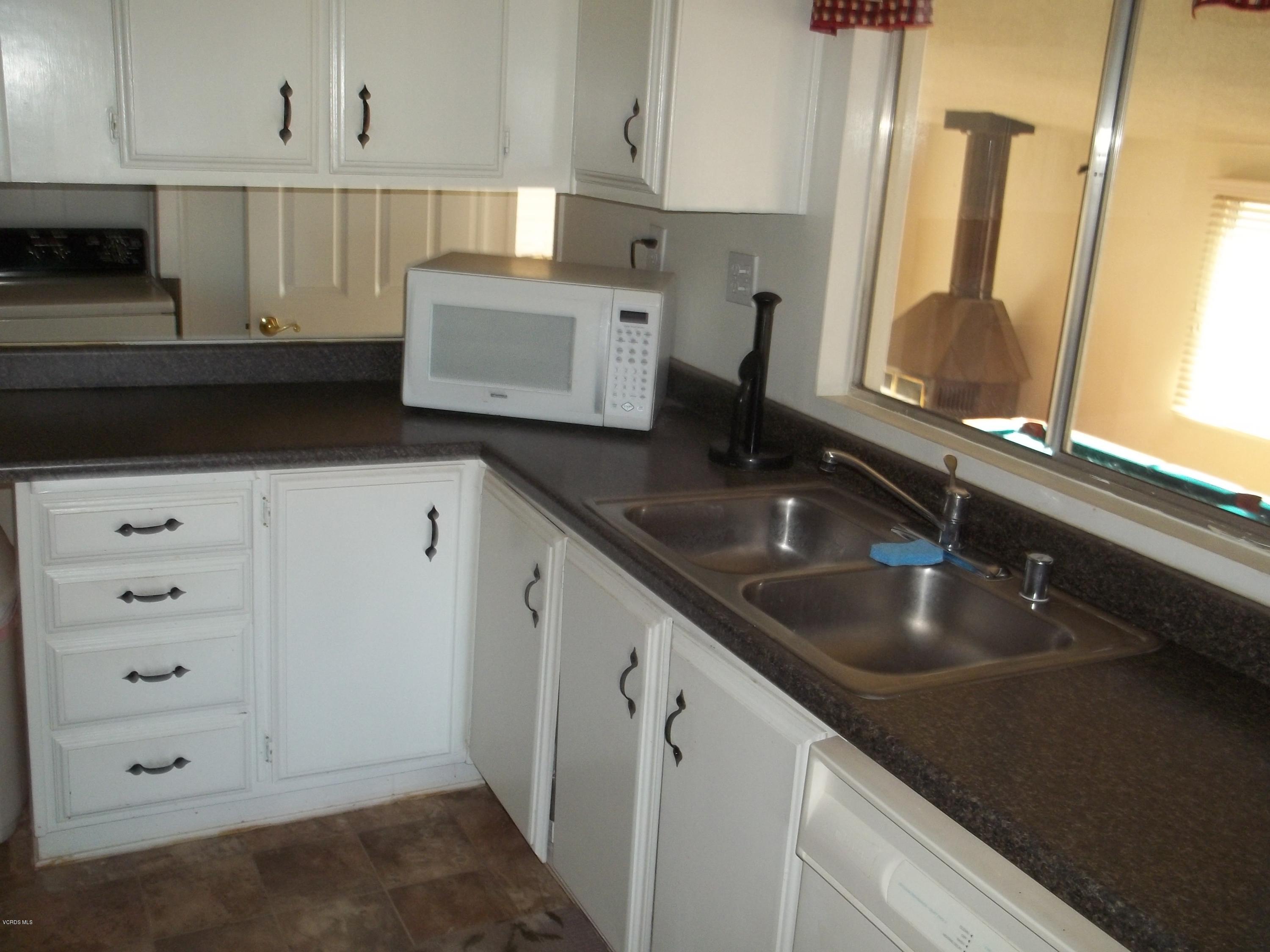 19370 Water Canyon Road Tehachapi, CA 93561 - Photo 23 of 38 a kitchen with granite countertop a sink a stove and cabinets