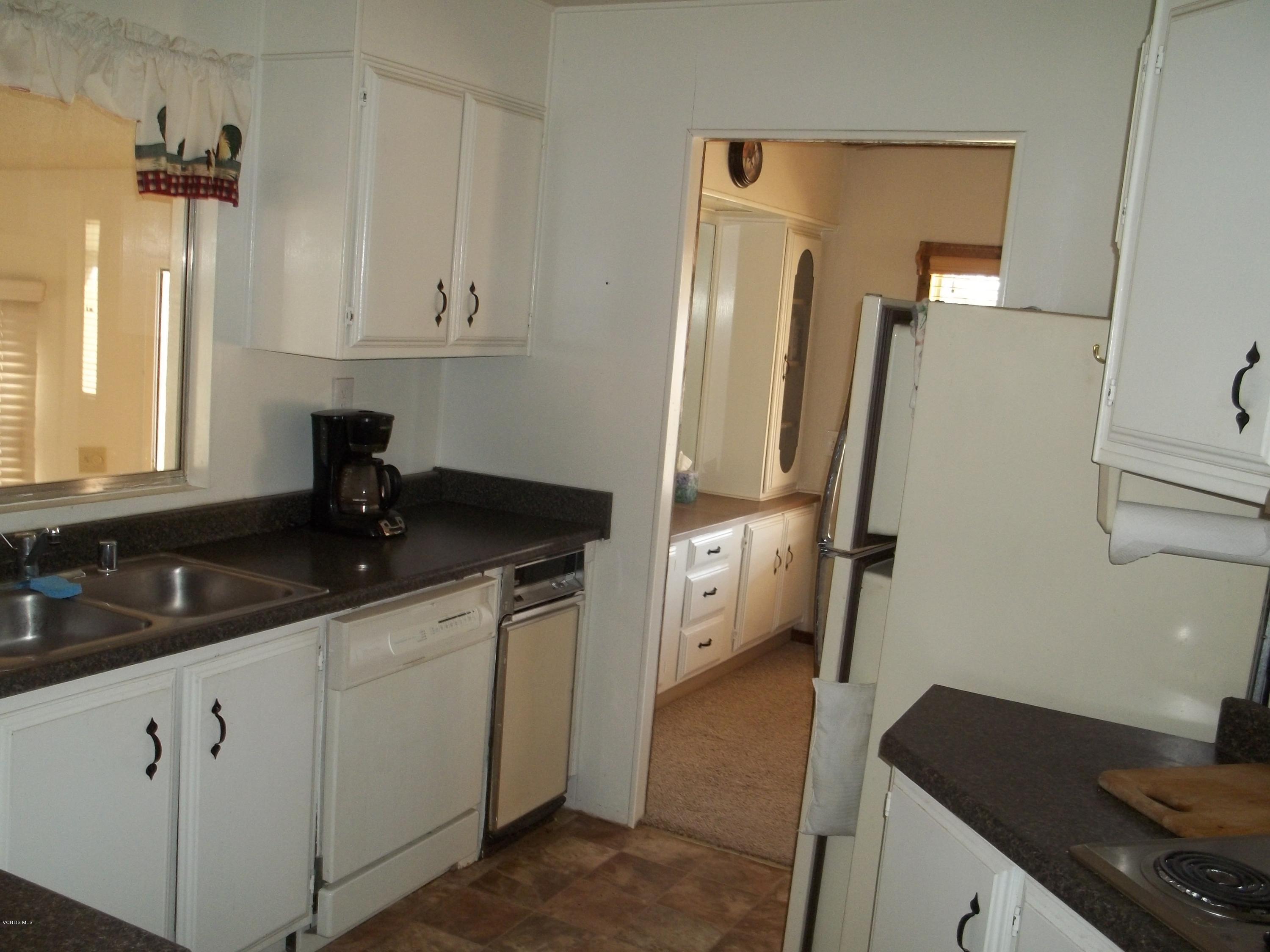 19370 Water Canyon Road Tehachapi, CA 93561 - Photo 27 of 38 a kitchen with granite countertop a sink stove and refrigerator