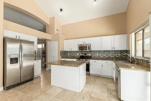 a kitchen with stainless steel appliances granite countertop a refrigerator and a stove
