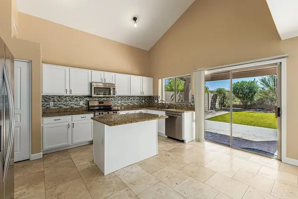 a kitchen with stainless steel appliances granite countertop a stove a sink and a refrigerator