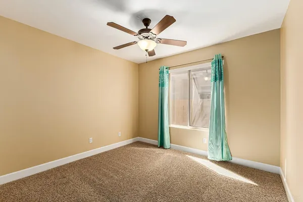 an empty room with closet and fan