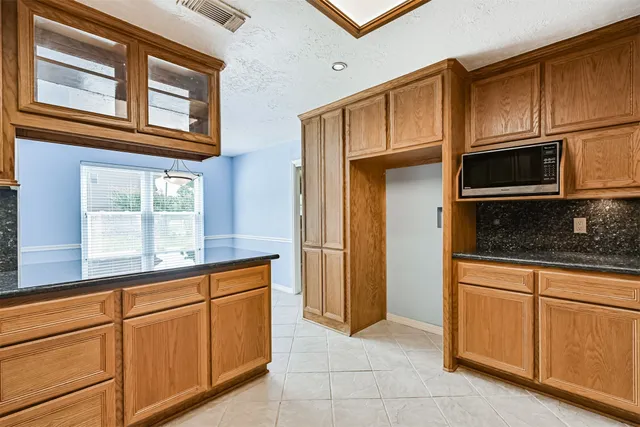 a kitchen with stainless steel appliances granite countertop a stove microwave and cabinets