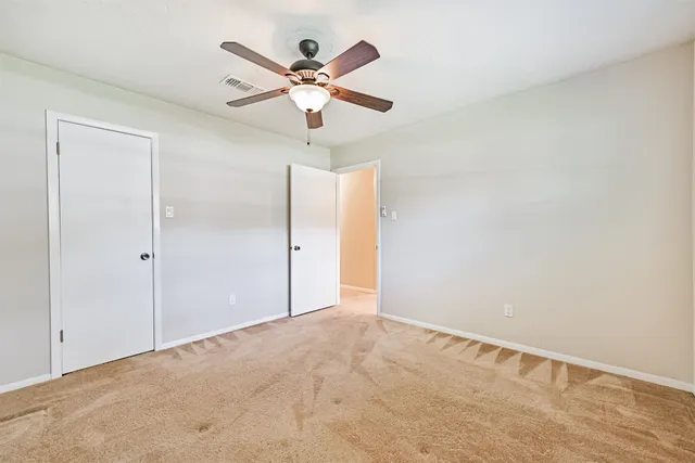 an empty room with a fan and a fan