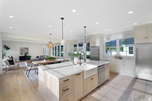 1952 South Comanche Circle Farmington, UT 84025 - Photo 52 of 52 Kitchen with stainless steel appliances, open floor plan, a center island with sink, light wood finished floors, and hanging light fixtures