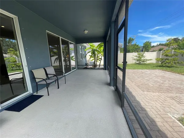 a view of a porch with furniture and floor to ceiling window