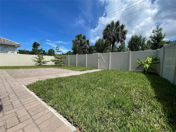 a view of backyard with swimming pool and seating space
