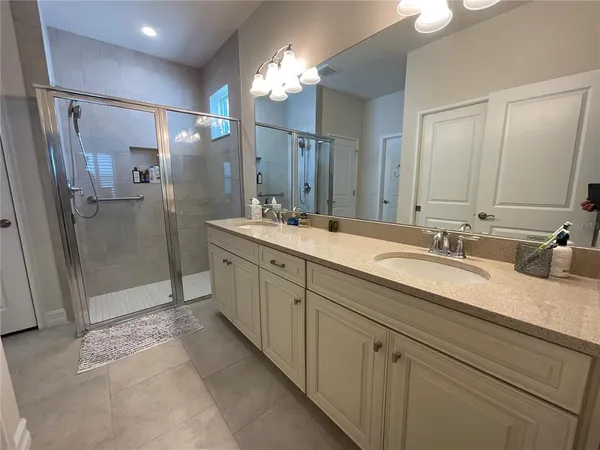 a spacious bathroom with double sink and shower