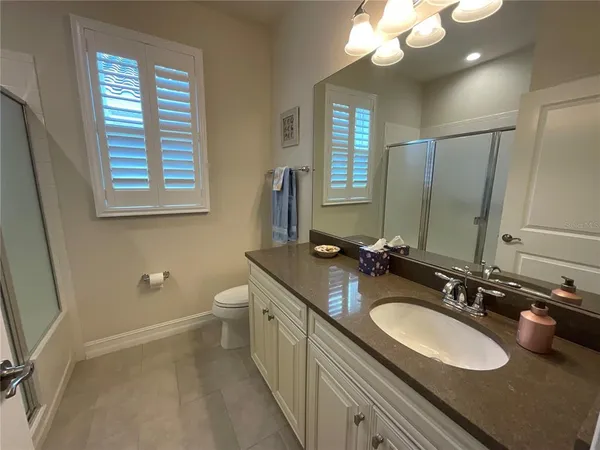 a bathroom with a double vanity sink a mirror and a toilet