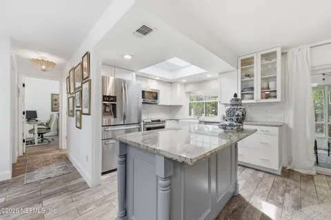 a kitchen with granite countertop a sink stainless steel appliances and cabinets