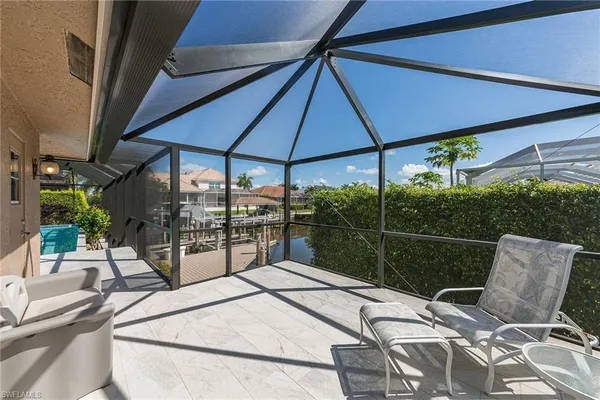 a view of a patio with a table and chairs under an umbrella
