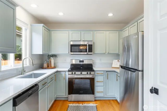 a kitchen with stainless steel appliances a refrigerator sink and microwave