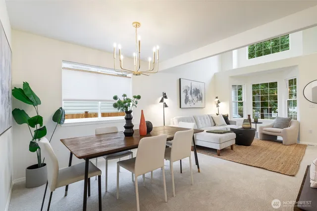 a dining room with furniture a potted plant and wooden floor