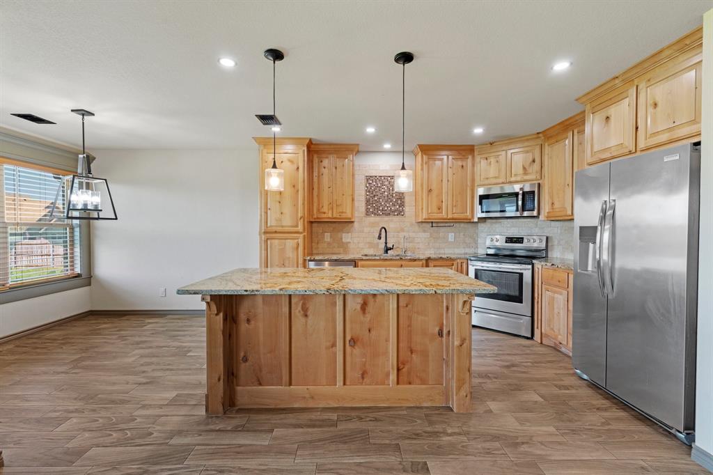 2387 County Road 407 Nemo, TX 76070 - Photo 8 of 30 a kitchen with kitchen island a refrigerator a stove a sink and a island