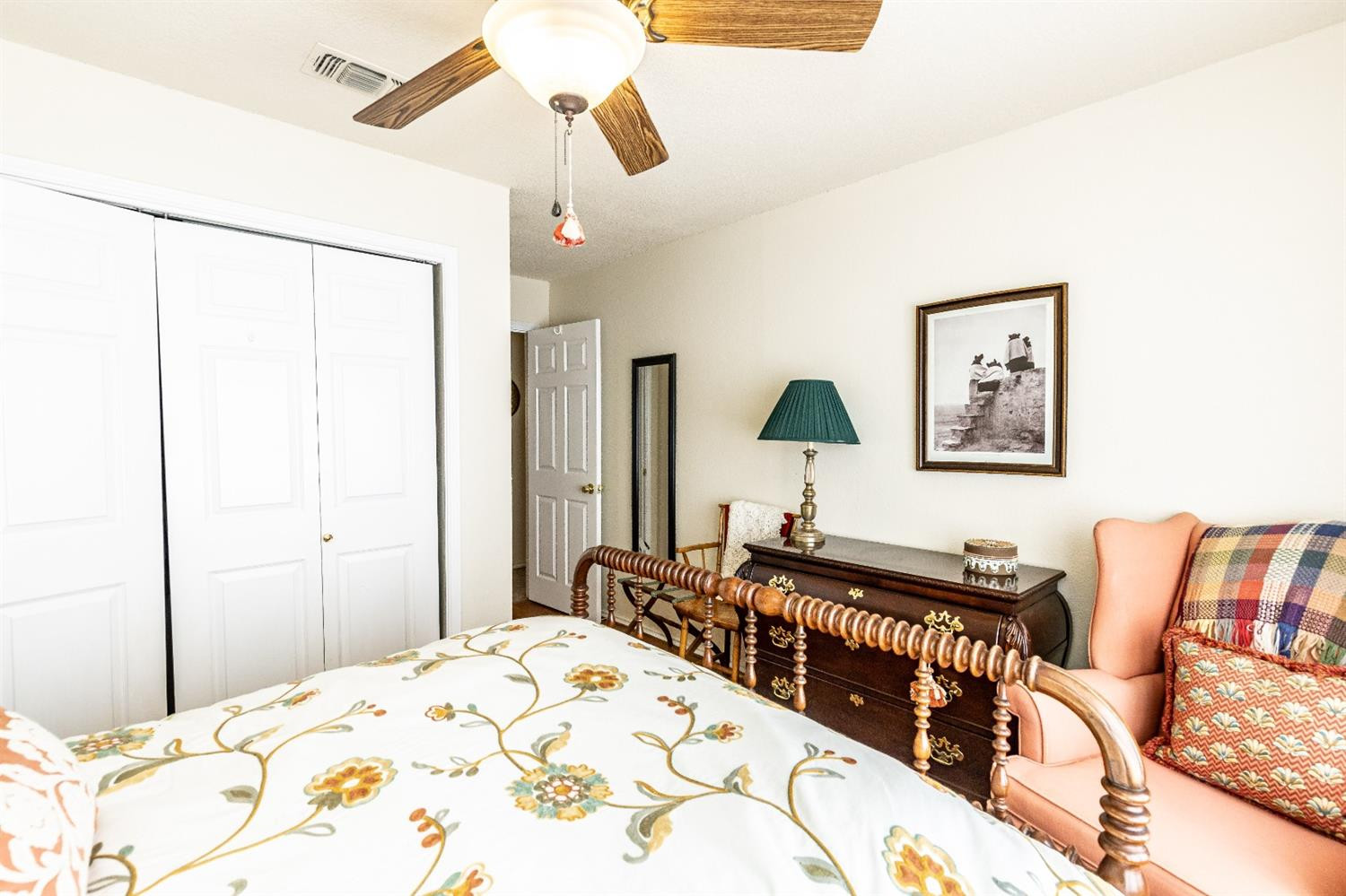 5221 84th Street Lubbock, TX 79424 - Photo 29 of 42 a bedroom with a bed a dresser and a chandelier