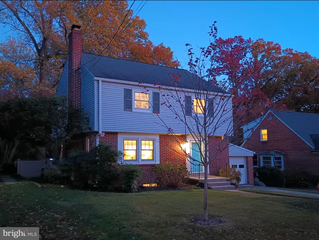 a front view of a house with a yard and tree s