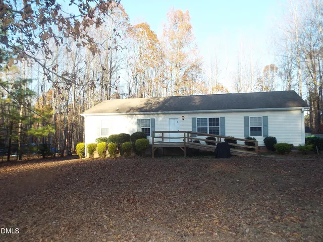 a view of a house with a yard and sitting area