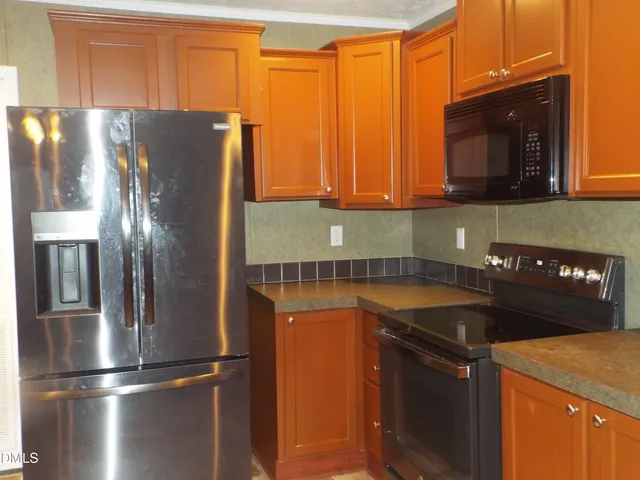 a kitchen with stainless steel appliances granite countertop a refrigerator a stove and a sink