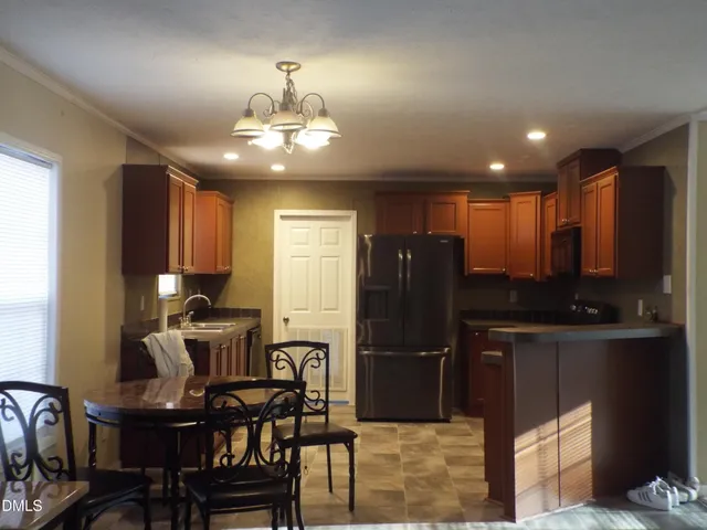 a kitchen with refrigerator and chairs