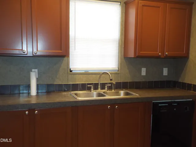 a kitchen with kitchen island granite countertop a sink window and cabinets