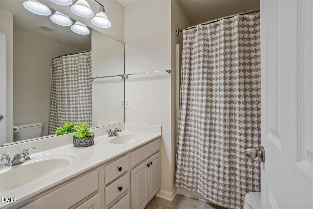 2746 Laurel Cherry Street Raleigh, NC 27612 - Photo 20 of 23 a bathroom with a sink a vanity and a shower