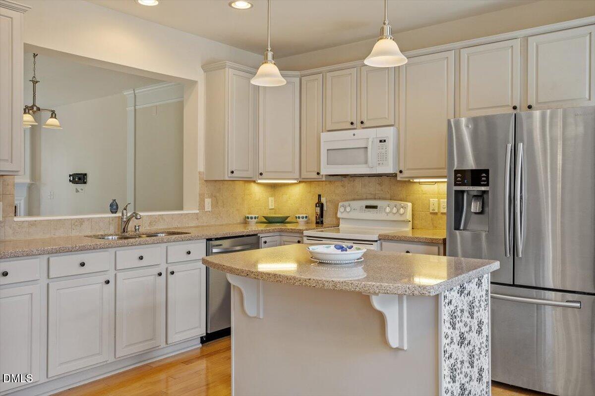 2746 Laurel Cherry Street Raleigh, NC 27612 - Photo 2 of 23 a kitchen with stainless steel appliances a stove a sink a refrigerator a center island and cabinets
