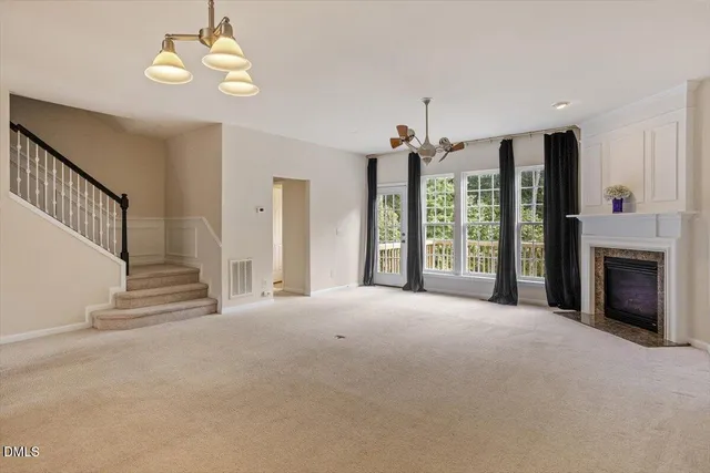 a view of an empty room with a fireplace and a window