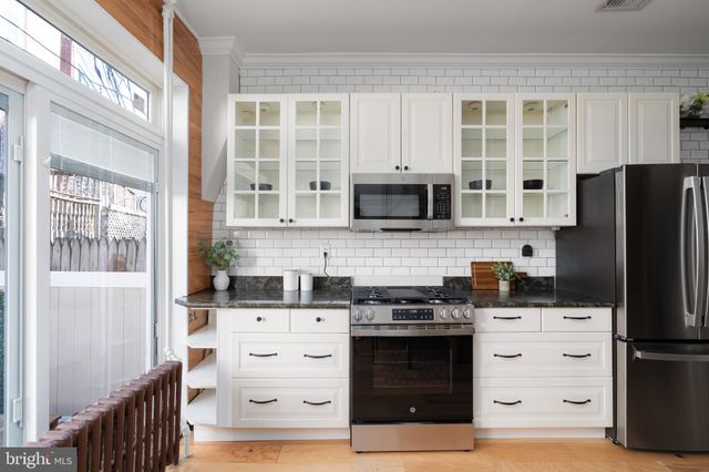 a kitchen with stainless steel appliances white cabinets and a refrigerator
