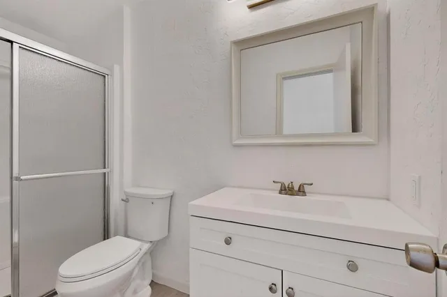 a bathroom with a toilet a sink a vanity and mirror