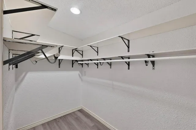 a view of walk in closet with empty racks
